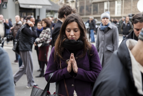  A girl prays for the victims on the crime scene outside the Carillon bar in Paris, France.