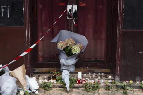  Flowers and candles in memory of the victims at the entrance of the bar Le Carillon